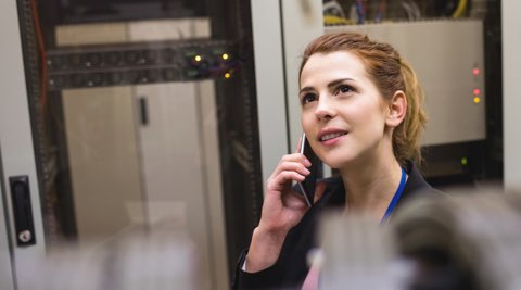 Woman at the office talking on a cell phone.